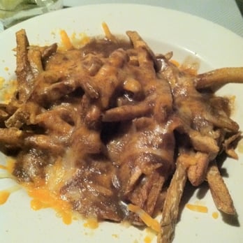 Rumor's Comedy Club - a plate of french fries covered in gravy - Comedy Clubs Near Me - Winnipeg, Manitoba Rumor's Comedy Club - a plate of french fries covered in gravy - Comedy Clubs Near Me - Winnipeg, Manitoba