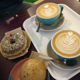 Oatmilk and regular milk lattes with coffi glaze and white chocolate holiday donuts Oatmilk and regular milk lattes with coffi glaze and white chocolate holiday donuts