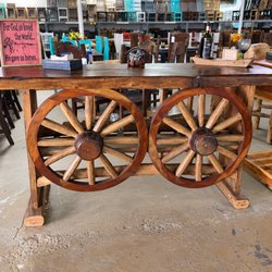 Rustic Furniture Warehouse Sales - Rustic Western bar featuring two large wagon wheels and a beautiful natural wood top for a standout look and built in bottle holder.