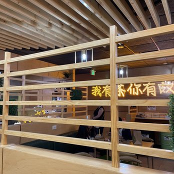 Inside Taichi with with wooden tables and dividers.