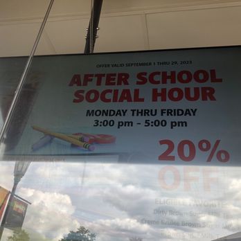Gong Cha - Plainview - The image shows a digital sign inside a store window, promoting an after school social hour offer valid from September 1 to September 29, 2023. The sign indicates the hours as Monday through Friday, 3:00 pm to 5:00 pm, and highlights a 20% discount. The sign features images of school supplies such as pencils and scissors, and the reflection of the sky and clouds can be seen on the glass. - Bubble Tea Near Me - Plainview, New York