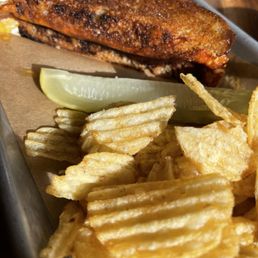 1/2 of our yummy grilled cheese with mustard on Local sourdough w/chips and pickle.