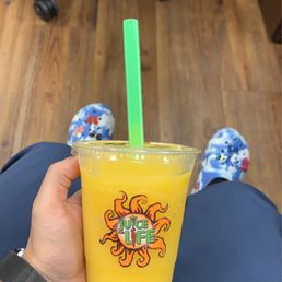 a person holding a cup of juice