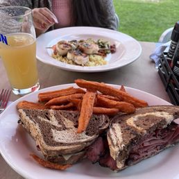 Shrimp and scallop skewers along with a pastrami sandwich.