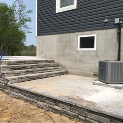 Northern Concrete Services - Exterior stamped concrete patio with steps and stone retaining wall