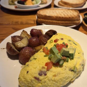 Alexanders Cafe - The Cali omelette with herb roasted potatoes: Applewood smoked bacon, avocado, tomatoes, scallions and Havarti cheese. - Diners Near Me - Elgin, Illinois