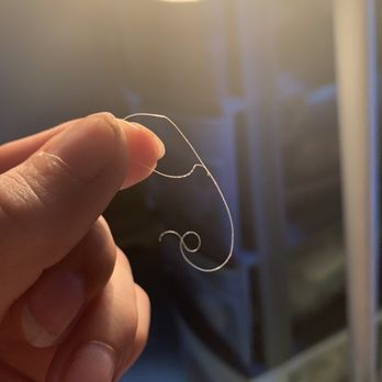 La Granja - a hand holding a piece of wire - Peruvian Near Me - Pompano Beach, Florida