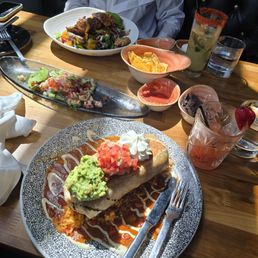Chicken burrito, ceviche, fajita salad, salsa, beans, chips, virgin mojito, and strawberry margarita.