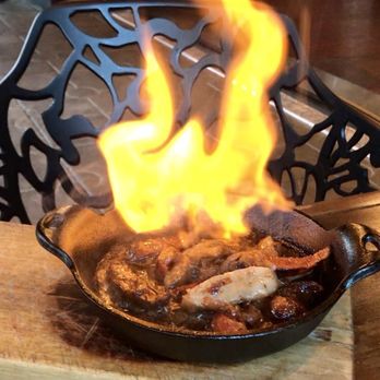 Olé Tapas Bar & Kitchen - The Grilled Spanish Salchichas, served flambéed tableside at Cafe Sevilla. - Spanish Near Me - Long Beach, California Olé Tapas Bar & Kitchen - The Grilled Spanish Salchichas, served flambéed tableside at Cafe Sevilla. - Spanish Near Me - Long Beach, California