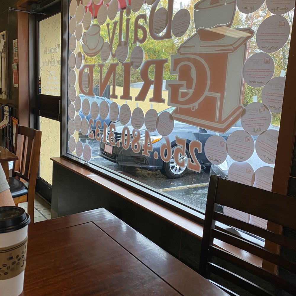 Daily Grind - a coffee cup on a table in front of a window - Coffee & Tea Near Me - Talladega, Alabama
