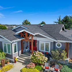 Mt Baker Roofing - A stunning aerial view of a modern home featuring a sleek and durable asphalt shingle roof, complementing the vibrant landscaping.