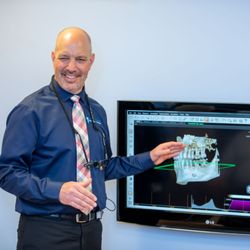 Shoreline Periodontics & Dental Implants - Dr. Gregory Toback talking to a patient about their surgical plan