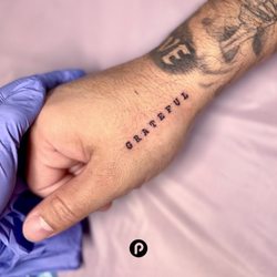 Skyn Spot - Type tattoo on the hand by our tattoo artist, Paige