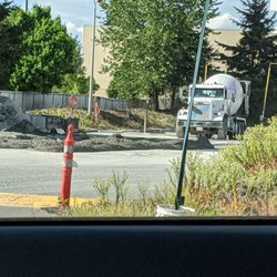 Cement mixer mixing a load of concrete (the yellow pipe is dispensing water)