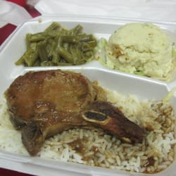 Smothered pork chop, rice and gravy, veggies and potato salad