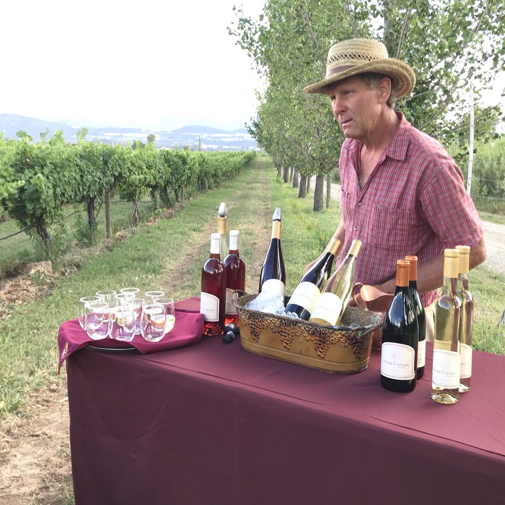 Stone Cottage Cellars - a man standing behind a wine tasting table - Wineries Near Me - Paonia, Colorado Stone Cottage Cellars - a man standing behind a wine tasting table - Wineries Near Me - Paonia, Colorado