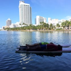Hirooka Surf and Sport - Paddleboard yoga under a bridge with a cup of wine