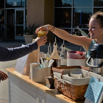 Picnic Grounds - a woman handing a sandwich to another woman - Coffee & Tea Near Me