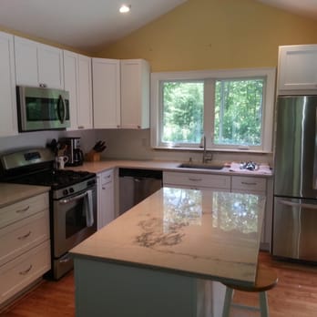 Shoreline Design - a kitchen with white cabinets and stainless steel appliances - General Contractors Near Me - Shoreham, New York