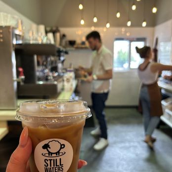 Still Waters Coffee - a hand holding a cup of coffee - Coffee & Tea Near Me - Greeley, Colorado Still Waters Coffee - a hand holding a cup of coffee - Coffee & Tea Near Me - Greeley, Colorado
