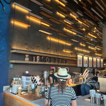 Starbucks - a woman standing at a counter in a coffee shop - Coffee & Tea Near Me - Miami Beach, Florida Starbucks - a woman standing at a counter in a coffee shop - Coffee & Tea Near Me - Miami Beach, Florida