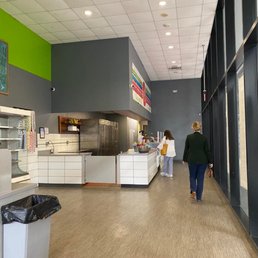 a woman walking through a cafeteria a woman walking through a cafeteria