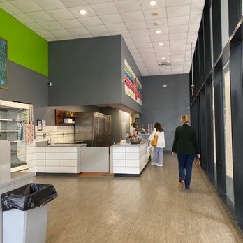 Green To Go - a woman walking through a cafeteria - Breakfast & Brunch Near Me - New Orleans, Louisiana Green To Go - a woman walking through a cafeteria - Breakfast & Brunch Near Me - New Orleans, Louisiana