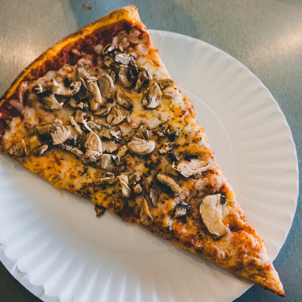 a slice of pizza on a paper plate