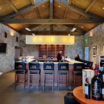 Beaulieu Vineyard - a bar with wine bottles on the counter - Wineries Near Me - Rutherford, California