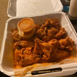 a styrofoam takeout box of chicken wings