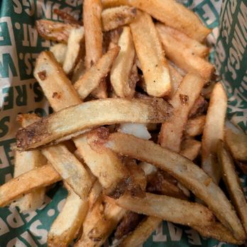 Wingstop - Fries - A serving of French fries in a paper-lined basket, with some fries showing a golden-brown color and slight crispiness. - Chicken Wings Near Me - Bowie, Maryland