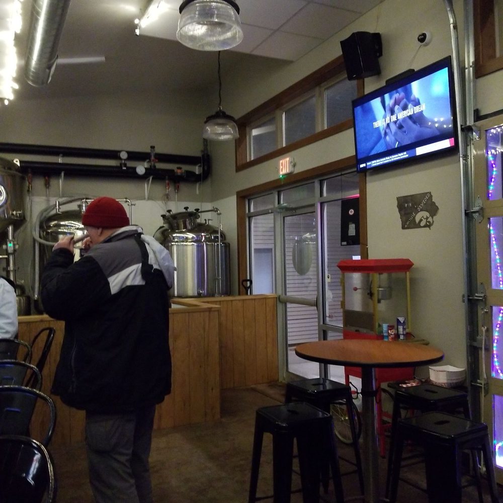 House Divided Brewery - a man standing in front of a television - Breweries Near Me - Ely, Iowa House Divided Brewery - a man standing in front of a television - Breweries Near Me - Ely, Iowa