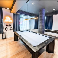 3Thirty3 Apartments - A high-end game room offers residents access to a professional-grade billiard table and a sleek shuffleboard table in a moder...
