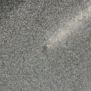 Barefoot Surfaces - Northwest side repair - A detailed view of a speckled concrete floor with a rough texture and small aggregate particles. - Flooring Near Me - Gilbert, Arizona