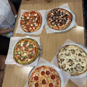 Firenza Pizza - four different pizzas on a table - Pizza Near Me - Winchester, Virginia