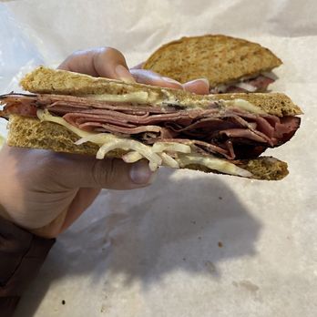 Harvest Moon Deli - a person holding a sandwich - Sandwiches Near Me - Waterville, Maine