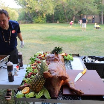 Prairie Smoke & Spice - a man preparing a large roasting pig - Food Trucks Near Me Prairie Smoke & Spice - a man preparing a large roasting pig - Food Trucks Near Me