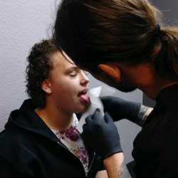 Siren Body Jewelry Tattoo & Piercing - Erix performing a tongue piercing at SirenBodyJewelry Tattoo & Piercing