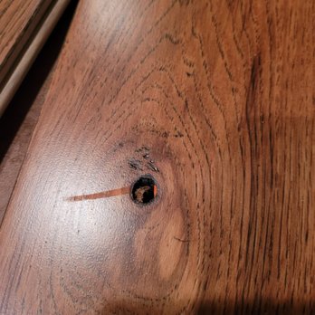 Lumber Liquidators - knot hole not filled - orange marker came from factory this way - Building Supplies Near Me - South Bend, Indiana