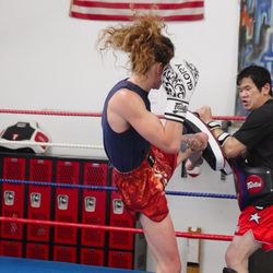 Coach Rob coaching and holding pads for a top fighter