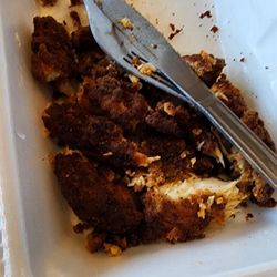 Overcooked chicken tenders served in a Styrofoam box.