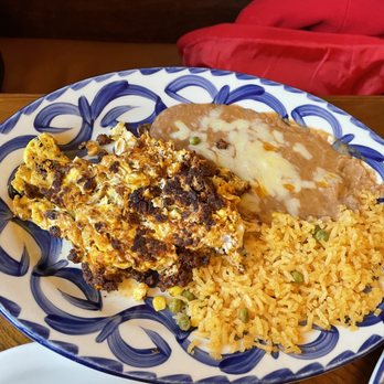 El Rodeo - Chorizo with egg, beans and rice - A colorful plate features Mexican rice, refried beans with melted cheese, and a casserole with eggs and meat, served at a restaurant. - Mexican Near Me - Concord, New Hampshire