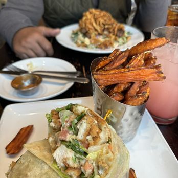 Mike's Grillhouse - Foreground: Caesar chicken wrap with sweet potato fries, really, really good. Background steak salad with fried onions on top. - American Near Me - Modesto, California