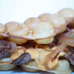 TATAS Muffles - Muffles Cheesesteak Im Teig eingebackener Mozzarella, mit glasierten Zwiebeln, gelber und roter Paprika und selbstgemachten 3-Käse Soße