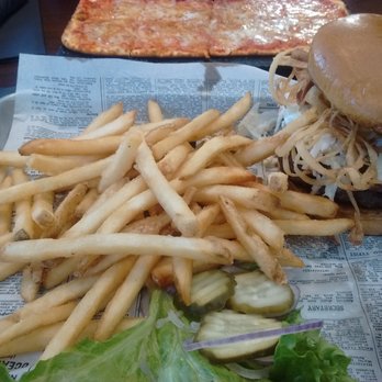 The Brass Tap - Korean BBQ burger with pizza in background - American Near Me - Cedar Falls, Iowa The Brass Tap - Korean BBQ burger with pizza in background - American Near Me - Cedar Falls, Iowa