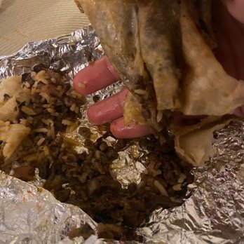 El Taco Llama - a hand holding a piece of food - Mexican Near Me - Reseda, California