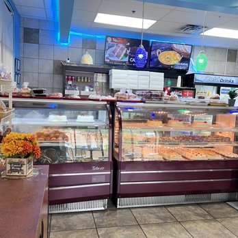 Hot Breads - a woman standing in front of a display of baked goods - Indian Near Me - Alpharetta, Georgia Hot Breads - a woman standing in front of a display of baked goods - Indian Near Me - Alpharetta, Georgia