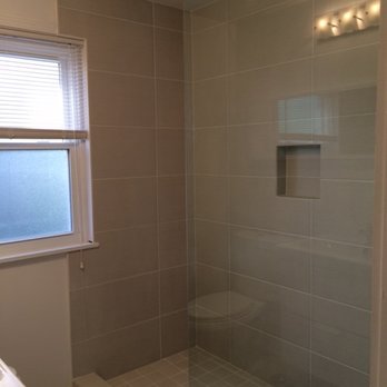 First Class Tile - a shower and sink in a bathroom - Flooring Near Me