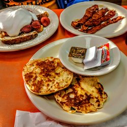 Goody Goody Omelet House Restaurant - French toast with strawberries and whipped cream with crispy Bacon and English Muffins.