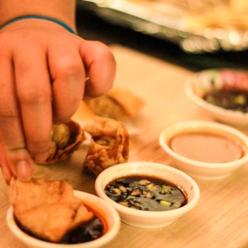 WontonTiva - a person putting dipping sauce on a wontona - Asian Fusion Near Me - Brooklyn, New York WontonTiva - a person putting dipping sauce on a wontona - Asian Fusion Near Me - Brooklyn, New York
